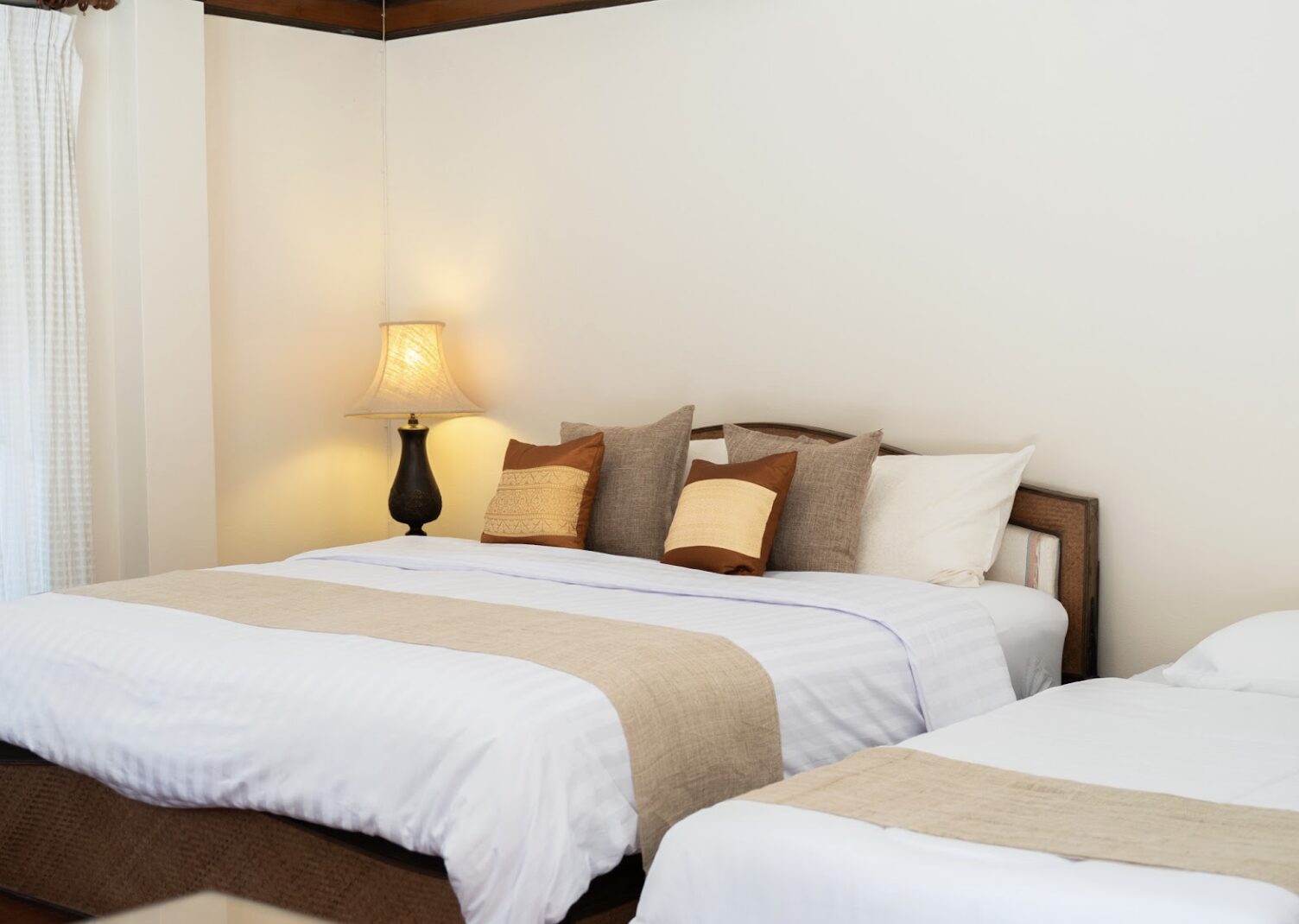 A warm bungalow bedroom lit by soft lamplight